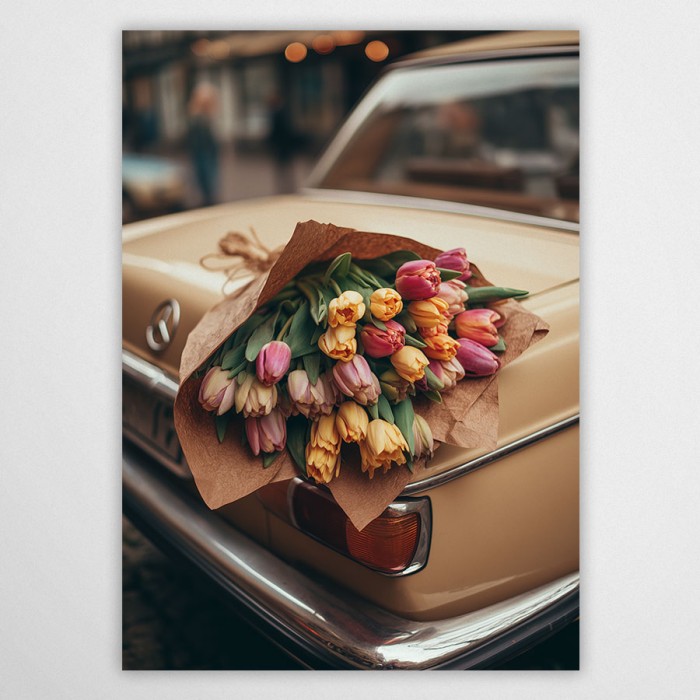 Fotografia artystyczna przedstawiająca duży bukiet kolorowych tulipanów (różowych, żółtych, pomarańczowych) owiniętych w brązowy papier, leżący na bagażniku beżowego, zabytkowego samochodu marki Mercedes. Klimat retro i nostalgiczny.